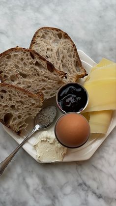 a plate with bread, butter and an egg on it