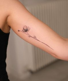 a woman's arm with a flower tattoo on the back of her left arm