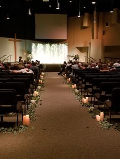 an empty church with candles on the aisle