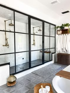 a bathroom with glass doors and stone flooring in front of the bathtub is shown