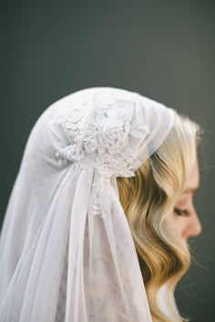 a woman wearing a veil with flowers on the back of her head and long blonde hair