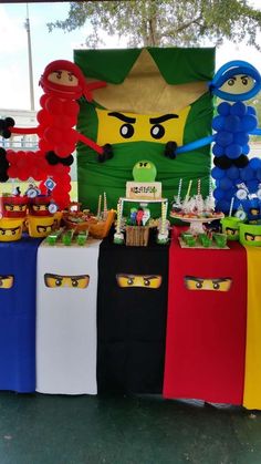 an assortment of items displayed on tables at a birthday party in the shape of legos