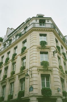 an old building with ivy growing on the windows and balconies in paris, france