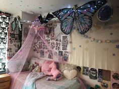 a bedroom decorated in pastel colors with butterflies on the ceiling