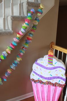 a decorated cupcake sitting on top of a wooden table next to a stair case