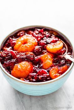 a blue bowl filled with cranberry sauce on top of a white tablecloth