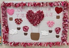 valentine's day bulletin board with hearts in the air and flowers on it that say love is in the air