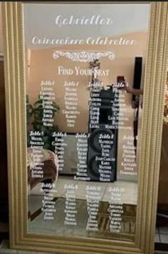 a large gold framed mirror with a seating chart on it's front and side