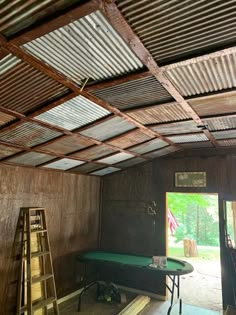 the inside of a building that is being built with wood and corrugated sheets on the ceiling