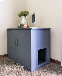 a gray cabinet with a white vase on top and a computer monitor sitting on top of it