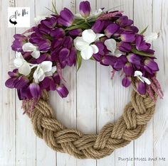 a rope wreath with purple and white flowers