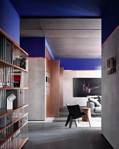 an open living room with bookshelves and a painting on the wall behind it