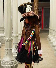 a woman wearing a costume and hat walking down the street with her hand on her hip