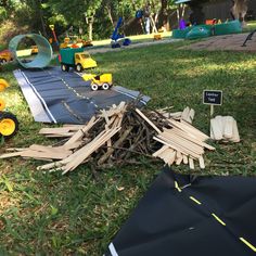 a pile of wood sitting on top of a lush green field next to a playground