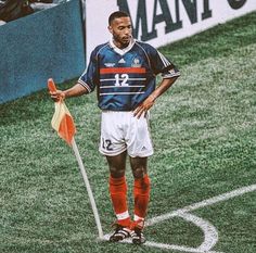 a man standing on top of a soccer field holding a flag