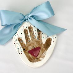 a paper plate with a hand painted on it and a blue ribbon around the edge