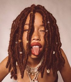 a woman with dreadlocks sticking her tongue out