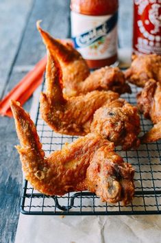 fried chicken wings on a cooling rack with sauce