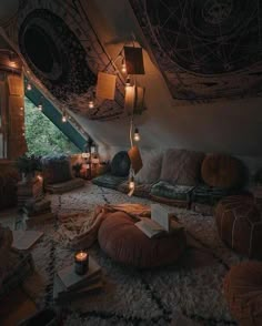 a room with lots of pillows and lights on the ceiling is lit up by candles