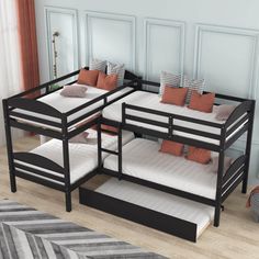 three bunk beds with white and brown pillows in a room next to a striped rug