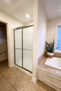 a bath tub sitting next to a walk in shower