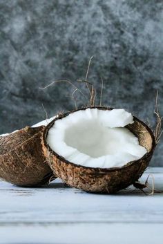 two halves of coconuts sitting on top of a wooden table