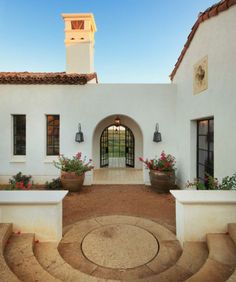 the entrance to a house with potted plants