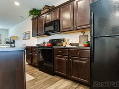 a kitchen with wooden cabinets and black appliances