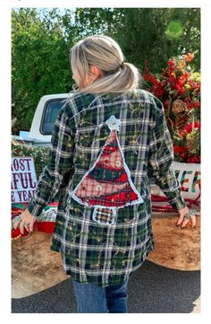 a woman standing in front of a truck with a christmas tree on it