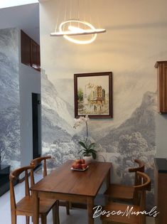 a dining room table with two chairs and a bowl of fruit on it