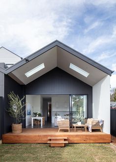 a modern house with an open roof and wooden steps leading up to the front door