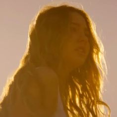 a woman with long hair standing in the sun