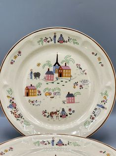 two plates with designs on them sitting next to each other in front of a gray background