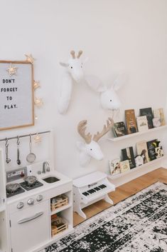 a kitchen with white appliances and deer heads on the wall above it's stove