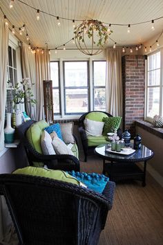 the living room is decorated with wicker furniture and string lights hanging from the ceiling