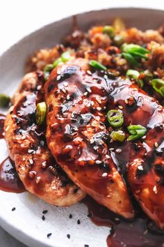 a plate with chicken, rice and vegetables covered in teriyaki sauce on it