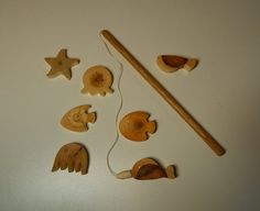 an assortment of wooden toys and tools on a white surface, including a stick with wood carving