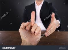 a man in a business suit pointing at something with his fingers on the table,