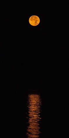 the full moon is reflected in the water