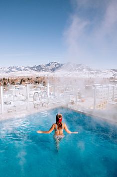 a woman in a hot tub on top of a snow covered mountain