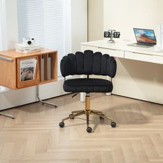 a black chair sitting in front of a desk with a laptop computer on top of it