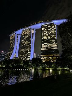 the lights on the buildings are reflecting in the water at night, and there is no image here to provide a caption for