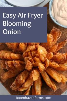 an easy air fryer blooming onion on a cutting board with ranch dip in the background