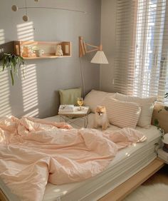 a small dog sitting on top of a bed in a room with white walls and windows