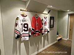 hockey jerseys are hung on the wall in this hallway