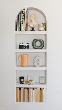 a white shelf with books and other items on it