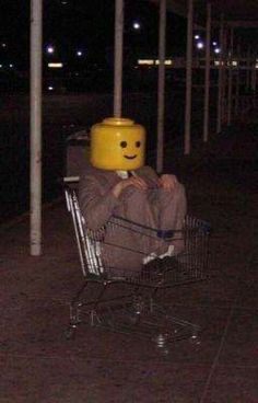 a person sitting in a shopping cart with a smiley face on it's head