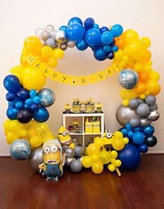 a birthday party with balloons and decorations in the shape of minion's head