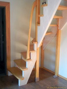 a wooden stair case next to a black door