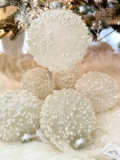 three white ornaments sitting on top of a fur covered floor